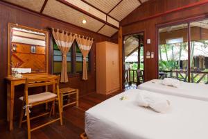 涛岛龟岛棕榈叶度假酒店的一间卧室设有两张床、一张桌子和窗户。
