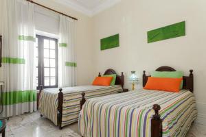 埃斯平霍18St. Hostel的卧室内的两张床,配有白色的墙壁和橙色的枕头