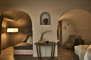 潘泰莱里亚Sikelia Luxury Hotel的酒店客房配有一张床铺和一张桌子。
