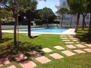 阿尔布费拉Jardins da Falesia的一座位于林地和建筑中的游泳池