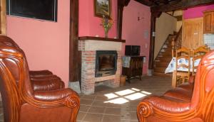 埃斯皮纳马Casa Rural La Torre de Espinama的客厅配有两把椅子和壁炉