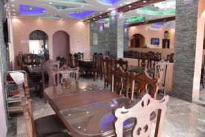 Al ‘AqarGreen Mountain Hotel Apartments的一间在房间内配有桌椅的餐厅