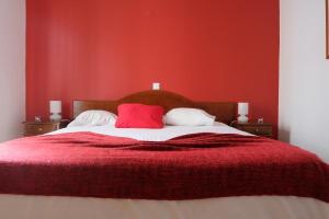 蓬塔德尔加达阿尔西德斯酒店的红色卧室配有带2个红色枕头的床