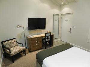 洛杉矶布伦特伍德酒店 的酒店客房配有一张床、一张书桌和一台电视。