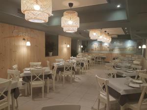 锡古恩萨麦松卡斯蒂利亚旅馆的餐厅设有白色的桌椅和吊灯。