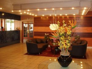 劳德代尔堡罗德岱堡机场红地毯酒店 的大堂设有两把椅子和花瓶