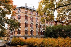 奥斯陆北欧旅舍 - 德施曼门10号的一座大型红砖建筑,前面有树木