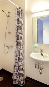 利勒哈默尔Lillehammer Stasjonen Hotel的一间带水槽和淋浴帘的浴室