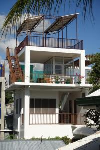 ArgaoBJs海滨住宿加早餐旅馆的一座大型白色建筑,设有阳台和棕榈树