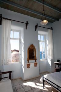 干尼亚潘多拉套房酒店的一间卧室设有2扇窗户、1张床和镜子