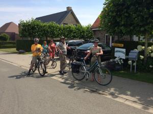 Langemark37温室住宿加早餐旅馆的一群人骑着自行车沿着街道走
