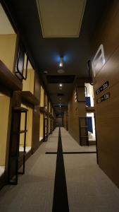 所泽市Spa胶囊旅馆（仅限男性）的一条有长走廊的建筑空走廊