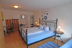 文斯Sendlerhof的一间卧室配有带蓝色床单的黑色床和一间浴室。