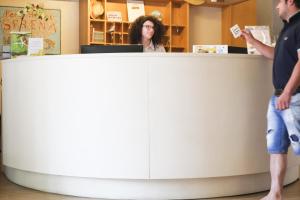 里米尼塞雷娜公园酒店的两个人站在商店的柜台上