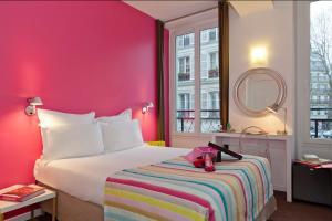 巴黎Hôtel Marais de Launay的酒店客房,配有一张粉红色墙壁的床
