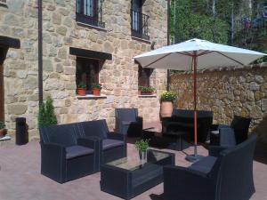 锡古恩萨阿拉米达公寓 的庭院配有椅子和桌子及遮阳伞