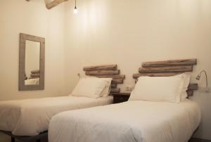奥尔韦加Hostal Gargal的配有2张床的白色墙壁和镜子