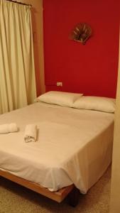 梅洛Residencial Castelar的卧室配有白色的床铺和红色的墙壁