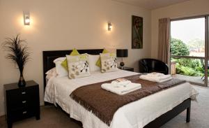 罗托鲁瓦红杉住宿加早餐旅馆的一间卧室配有带毛巾的床