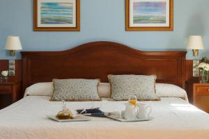 埃林艾米利奥酒店的一张有两盘食物的床