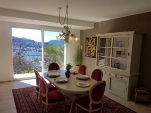 卢加诺阳光明媚的天堂公寓的一间带桌椅和窗户的用餐室