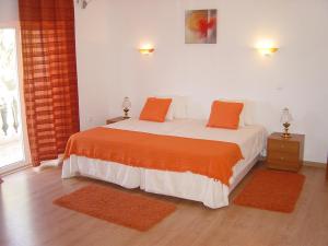 Vimieiro卡萨斯达维拉度假屋的一间卧室配有带橙色枕头的床