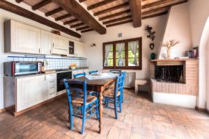 圣吉米纳诺拉科琳娜德乐其农庄的厨房配有木桌和蓝色椅子