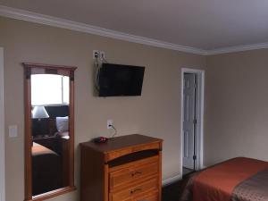 雷东多海滩海滨汽车旅馆的一间卧室配有一张床和一个墙上的电视梳妆台。