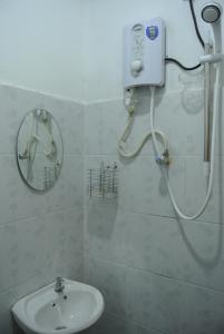 珍南海滩兰卡威波浪宾馆的带淋浴、水槽和镜子的浴室