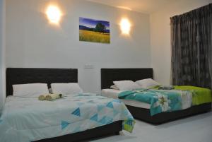 珍南海滩兰卡威波浪宾馆的一间卧室设有两张床,里面饲养着动物。