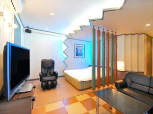 名古屋酒店.COM（仅限成人）的客房设有床、电视和沙发。