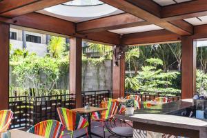 勒吉安Solia Legian Bali的庭院设有色彩缤纷的桌椅和窗户。