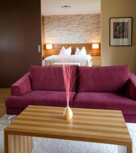 哈特贝格施雷纳斯伯格霍夫酒店的客厅配有紫色沙发和床。