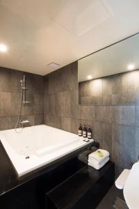 釜山弗莱特普瑞米尔南博酒店的带浴缸和盥洗盆的浴室