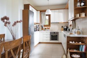 赛罗卡波斯Natica Mare Villas的厨房配有白色家电和桌椅