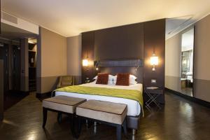 罗马罗马时代酒店的酒店客房带一张大床和两张椅子