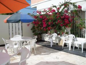 特尔马斯德里奥翁多喷泉酒店的庭院配有白色的桌椅和粉红色的鲜花