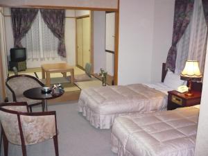 南砺五箇山温泉赤尾馆旅馆的酒店客房设有两张床和一张桌子。