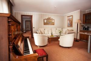 敖德萨奥塔达酒店的带沙发和钢琴的客厅