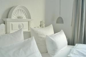 宾茨Villa Herbstwind in Binz的白色卧室配有白色枕头和架子