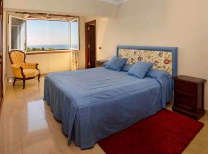 卡列罗港Casa Juanita的一间卧室配有蓝色的床、椅子和窗户
