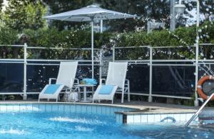 里乔内阿贝尼珥酒店的一个带椅子和遮阳伞的游泳池