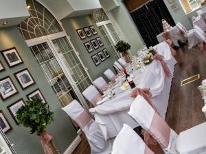 拉内利Stradey Park Hotel的享有带白色桌椅的用餐室的顶部景致