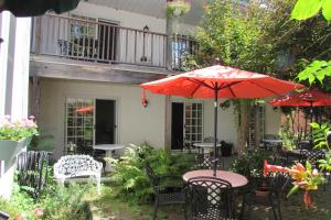 滨湖尼亚加拉Blairpen House Country Inn的一个带桌椅和遮阳伞的庭院