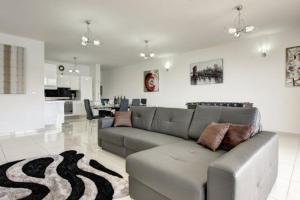 圣保罗湾城Water's Edge Apartment的客厅配有灰色的沙发和地毯。