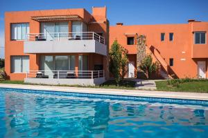 科洛尼亚-德尔萨克拉门托Lomas del Real Aparthotel的大楼前带游泳池的房子