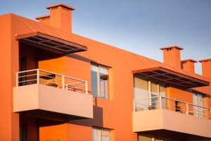 科洛尼亚-德尔萨克拉门托Lomas del Real Aparthotel的一座橙色的建筑,设有两个阳台