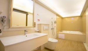 台南M宿花园汽车旅馆的一间带水槽、浴缸和卫生间的浴室
