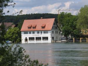 高莱茵河畔布辛根艾特莱茵河畔磨坊酒店&餐厅的河中一座建筑物