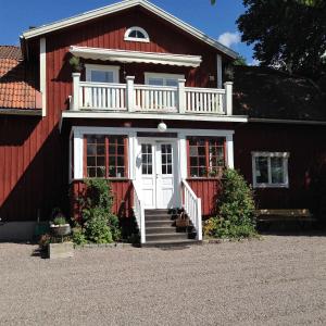 Bälinge克罗科斯塔乡村民宿 的红色的房子,设有白色的门和阳台